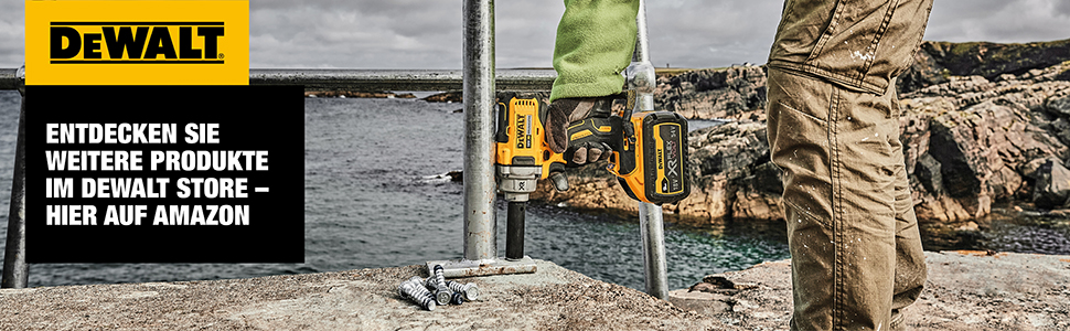 A man screws large screws in concrete by the sea with an impact wrench